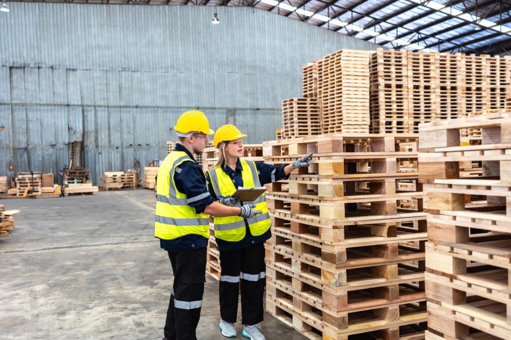 Warehouse Professionals Assessing Wooden Pallet Inventory